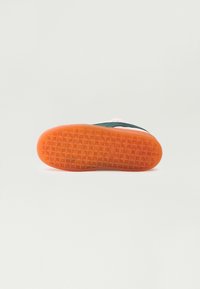 Semelle de sneaker avec un fond en caoutchouc orange texturé. Comprend une surface plate avec de petits motifs géométriques pour une meilleure adhérence. Pas de marque visible.