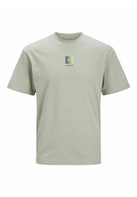 Camiseta de algodón verde claro con cuello redondo, mangas cortas y un logo cuadrado que presenta "9A" y el nombre de la marca en impresión oscura.
