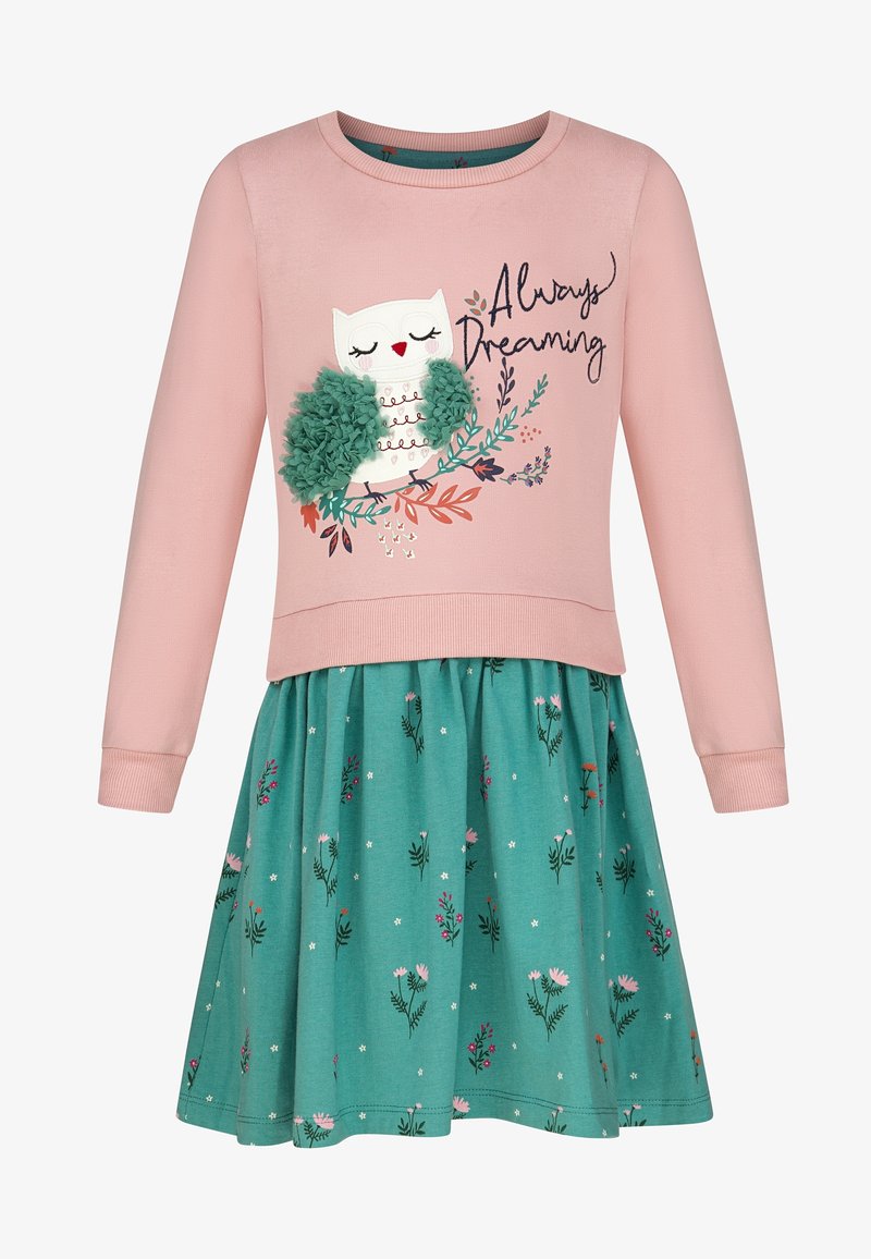 Haut de robe rose à manches longues avec un hibou texturé et le texte « Always Dreaming », associé à une jupe verte à fleurs attachée à la taille.