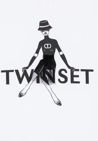 Maglietta bianca con grafica raffigurante una figura in un abito e cappello neri, decorata con dettagli in tulle nero. Sotto, la scritta "TWINSET".