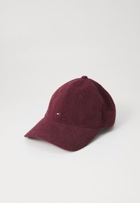 Casquette en velours côtelé bordeaux avec une couronne arrondie, une visière courbée et un petit logo accent, présentant un tissu texturé et des œillets de ventilation.