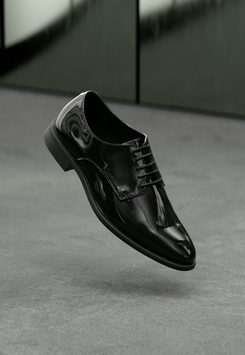 Chaussure habillée en cuir noir brillant avec lacets, flottant au-dessus d’une surface grise avec un arrière-plan sombre et flou.