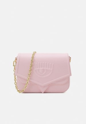 Bolso bandolera de cuero rosa claro con correa de cadena dorada y diseño de ojo en relieve en la solapa frontal.