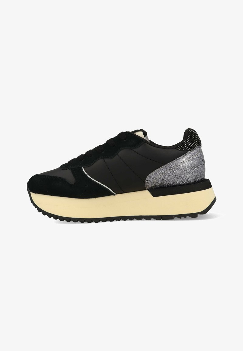 Sneaker nera in pelle liscia e suede, con un accento glitterato argento sul tallone, suola in gomma e lacci neri.