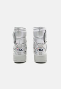 Hvite polstrede høyhælte sneakers med en blank finish, som har en fremtredende Fila-logo, rund tå og en teksturert såle med et bakre dragbånd.
