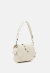 Cream leather handbag with rounded shape, short handle, fold-over flap, and silver hardware. Features embossed tag and contrasting stitching.