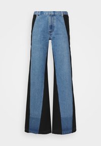 Laaja lahkeinen farkut sisältävät päällekkäin ommeltua muotoilua, jossa on vaalean ja tumman sinisen denimkangasta, mustat sivupaneelit ja raakareuna. Kestävä kangas.