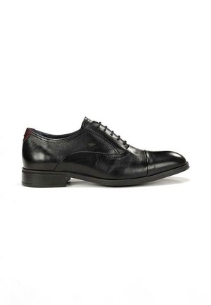 Chaussure Oxford pour homme en cuir noir avec bout golf, laçage fermé, talon bas, et accent bordeaux sur la languette du talon.