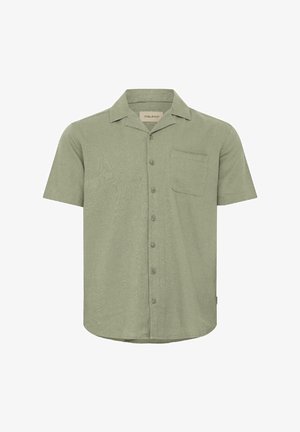 Lühikeste varrukatega, kraega särk heleoliivirohelises toonis. Valmistatud tekstuurse kangaga, ees nööbid ja üks rinnatasku.