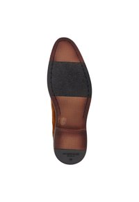 Semelle de chaussure en suède marron avec une traction en caoutchouc texturé. Comprend une section gris foncé et un marquage sur le talon. Design plat, bout arrondi.