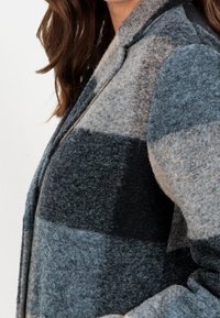 Grijze en blauwe geruite wollen blazer met een revers, uitgevoerd in een gestructureerde stof en een gestructureerde pasvorm, die grote vakken in verschillende tinten benadrukt.