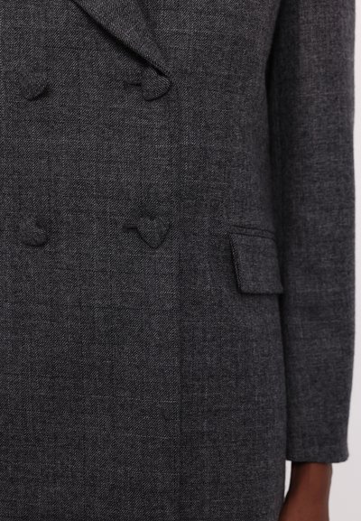 Blazer grigio doppiopetto realizzato in tessuto testurizzato, con due bottoni a forma di cuore e una tasca laterale. Design minimalista, vestibilità strutturata.
