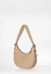 Beige leren schoudertas met een gebogen vorm en een dikke schouderband. Beschikt over een ritssluiting bovenaan en een minimalistisch ontwerp.