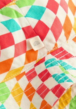 Kleurrijke geruite stof met een levendig patroon in rood, oranje, groen en blauw. Bevat een klein label met een regenboogontwerp.