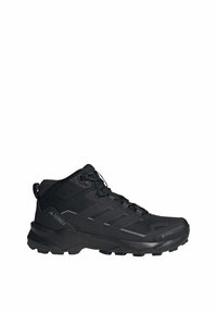 Czarne półwysokie buty trekkingowe z teksturowaną podeszwą, sznurowadłami oraz widocznym brandingiem "Terrex" i "Gore-Tex" po bokach.