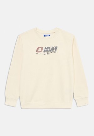 Duga majica krem boje s okruglim izrezom i dugim rukavima, na prsima s tiskom logotipa "Jack & Jones Intercontinental" u prigušenoj crvenoj i sivoj boji.