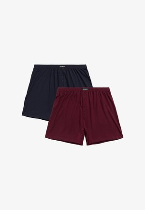 Dwie pary bokserek: jedna granatowa, a druga bordowa, obie z miękkiej bawełny, z elastycznym paskiem w talii i guzikami z przodu.
