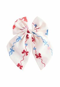 Noeud en tissu avec un fond blanc, présentant des motifs de nœuds rouges et bleus ainsi que des cœurs, et une texture lisse. Le design plié ajoute du volume.