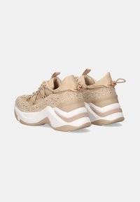 Zapatillas beigas con cordones, con un upper de tela texturizada, que presentan acentos de pedrería y una suela intermedia gruesa blanca con detalles beiges.