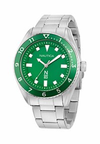 Roheline kell roostevabast terasest rihmaga, suured valged tunni numbrid ja hõbedased käed. Ümar korpus, bezel numbritega, bränd "Nautica" on nähtav.