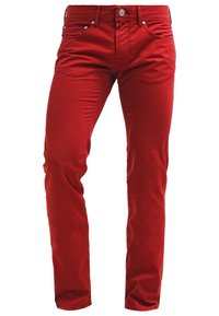 Jeans rossi in cotone con vestibilità slim, dotati di cinque tasche, passanti per cintura e hardware in metallo. Tessuto liscio, con minime pieghe.