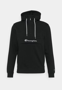 Felpa nera con cappuccio realizzata in misto cotone, con zip a un quarto, lacci bianchi e logo Champion bianco sul davanti.