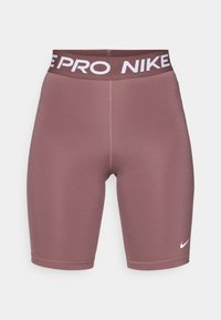 Nike Pro lühikesed püksid tuhmis lõheroosas värvitoonis, valmistatud siledast ja venivast materjalist, lai elastne vöökoht, millel on valge bränding ja logo.