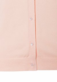 Ein Pfirsichfarbener Cardigan wird präsentiert, der eine gerippte Textur aufweist, eine Reihe von sechs Knöpfen hat und aus einem weichen Strickmaterial mit einer leicht taillierten Form besteht.