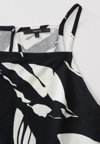 Robe à bretelles spaghetti noire et blanche avec motif abstrait de feuilles et étiquette intérieure indiquant la marque « someday » et la taille 36.