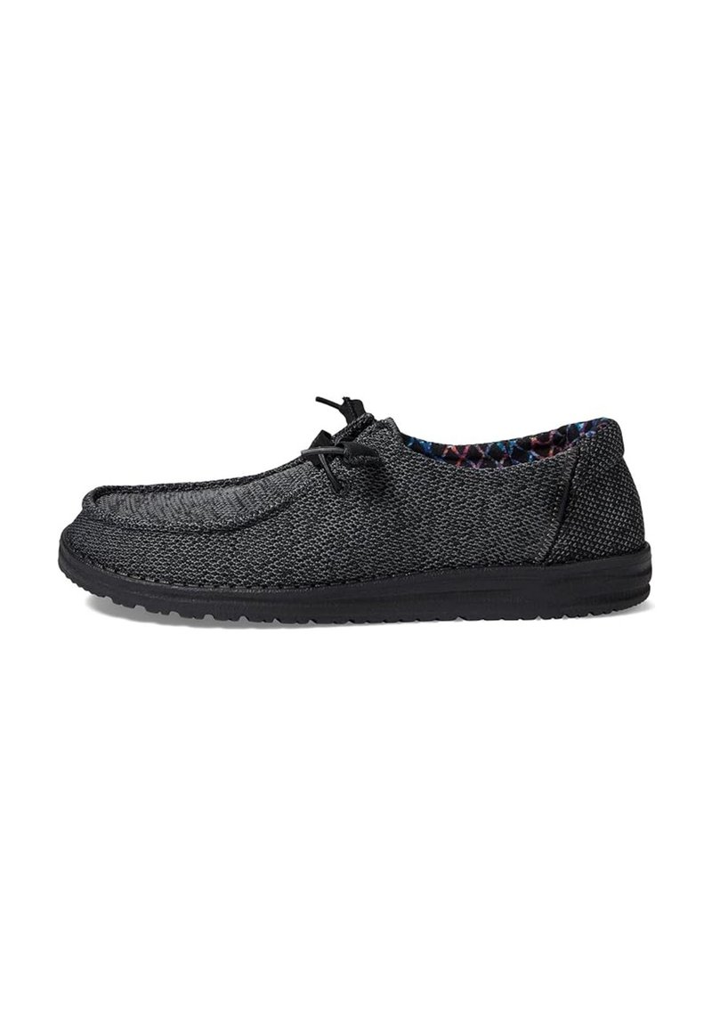 Zapato negro tipo slip-on hecho de tela texturizada, con punta redonda, interior con patrón contrastante y suela de goma flexible.