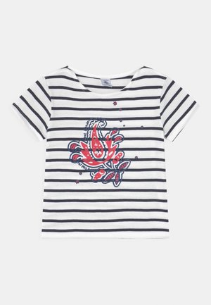 Camicia bianca a maniche corte con strisce orizzontali nere e un motivo floreale rosso e blu sul lato sinistro del petto.