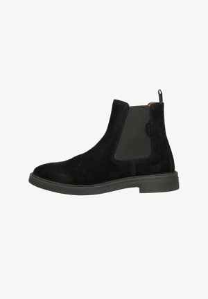 Black suede Chelsea boot with elastic side panels and pull tab. Rounded toe design and flat rubber sole. Smooth texture throughout.