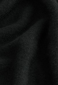 Tessuto nero testurizzato con una finitura morbida e tessuta, che mostra sottili variazioni di profondità e tonalità. Ideale per abbigliamento o tessuti per la casa.