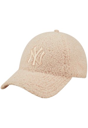 Lyse beige struktureret baseballkasket med buet skygge og hævet New York Yankees logo på frontpanelet.