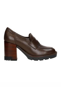 Bruine leren loafers met een ronde neus, voorzien van een gouden logo-accent en een forse houten blokhak met een gestructureerde zwarte zool.