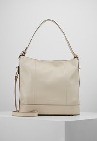 Beige läderhandväska med en slät yta, ett topphandtag och en justerbar axelrem. Har subtila sömmar och en logotypaccent.