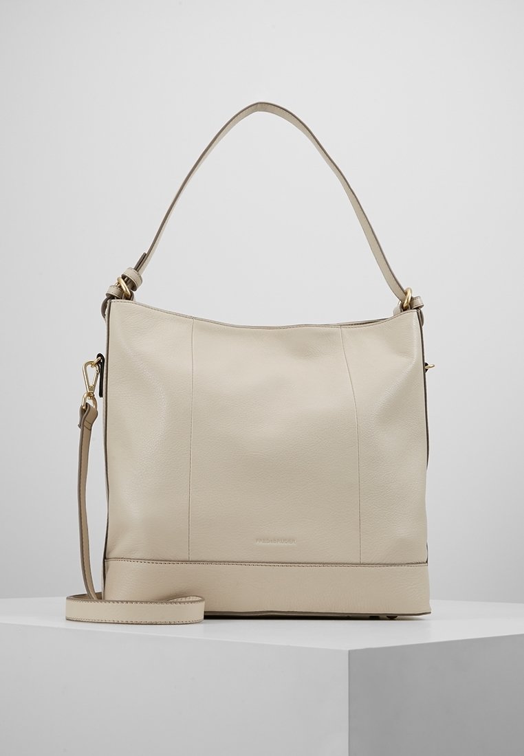 Beige läderhandväska med en slät yta, ett topphandtag och en justerbar axelrem. Har subtila sömmar och en logotypaccent.