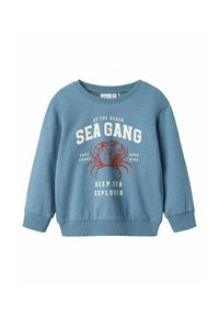 Felpa blu con collo rotondo, maniche lunghe e polsini a coste. Presenta una grafica di un granchio rosso e il testo: "SEA GANG DEEP SEA EXPLORER."