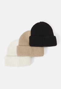 Tre strikkede hatte stablet: hvid, beige og sort. Ribbet tekstur med foldede manchetter, der viser et simpelt, funktionelt design.