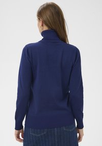 Pull à col roulé bleu marine avec poignets et ourlet côtelés, fabriqué en tissu doux. Présente une coupe ajustée avec une texture lisse.