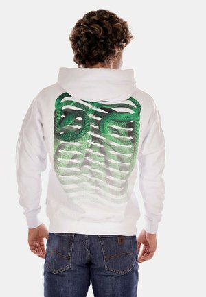 Felpa bianca con un design di un serpente verde sulla schiena, caratterizzata da un motivo a rete sfumata. Il tessuto appare morbido, con una vestibilità rilassata e cappuccio regolabile.