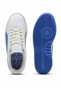 Weiße Leder-Sneaker mit blauen Akzenten, perforiertem Obermaterial und strukturiertem Gummisohle mit Fischgrätenmuster. Schnürdesign.