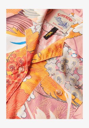 Camicia floreale colorata con motivi arancioni, rosa e gialli, chiusura frontale con bottoni, taschino sul petto e etichetta "Superdry Beach Casuals" all'interno del colletto.