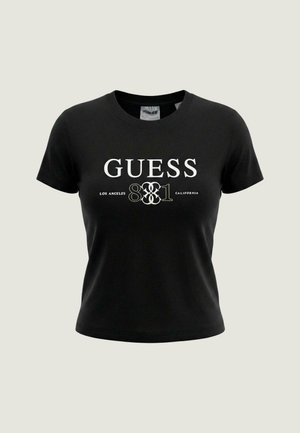 T-shirt nera a maniche corte, corta, con la scritta bianca "GUESS 1981 LOS ANGELES CALIFORNIA" stampata sul davanti.