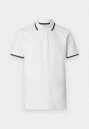 Biela polo košeľa s krátkym rukávom, čierne a béžové pruhy na golieri a okrajoch rukávov, dvojtlačidlová léga a mäkká bavlnená látka.