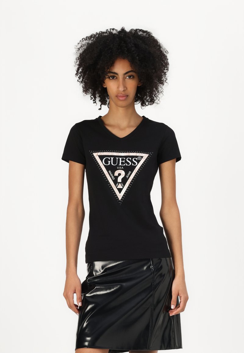 T-shirt in cotone nero con scollo a V, caratterizzato da un design a triangolo in rosa e bianco, impreziosito da strass. Abbinato a una gonna in vinile nera.