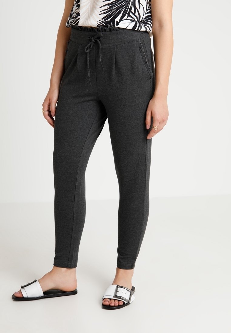 Mörkgrå joggingbyxor med dragsko i midjan, sidofickor och texturerat detaljer. Matchas med vita slides med svart sula och spänne.