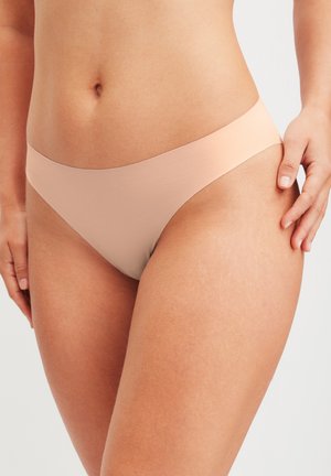 Bikini couleur nude sans coutures, avec une coupe taille basse, un tissu au toucher lisse, un style minimaliste et un dégradé subtil en haut.