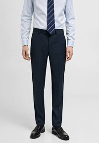 Pantaloni din stofă bleumarin, tăiați la comandă, cu față plată, realizați dintr-un material neted și ușor. Acestia au buzunare laterale subtile și un design clasic cu picior drept.