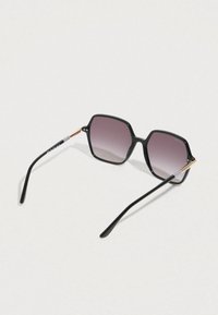 Czarne, ośmiokątne okulary przeciwsłoneczne z gradientowymi szarymi soczewkami. Charakteryzują się eleganckimi czarnymi oprawkami i złotymi akcentami na zausznikach. Obecne są teksturowane detale.